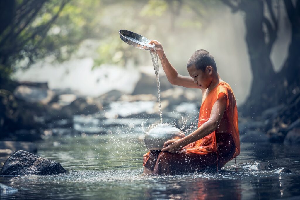 Un niño monje sentado frente a un río